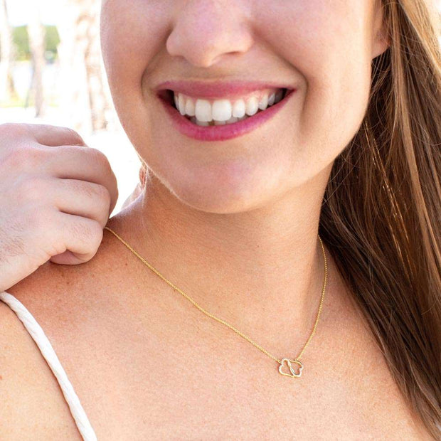 Woman wearing Wife Love Necklace with delicate pendant on gold chain.