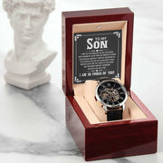 Openwork watch for son in luxury mahogany box, featuring black leather band and intricate openwork design.