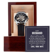 Openwork watch for men in a wooden box, featuring a black leather band and transparent dial showcasing intricate mechanics, ideal for gifting.