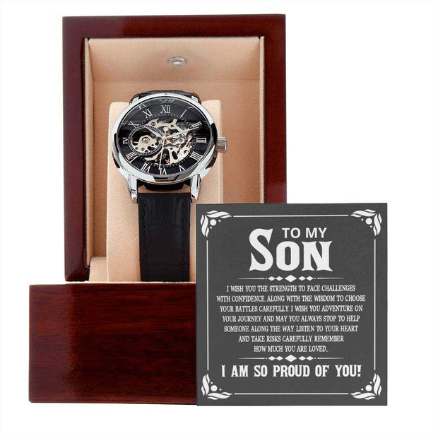 Openwork watch with black leather band in mahogany box, showcasing intricate mechanics and stylish design for son.