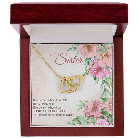 Interlocking Heart Necklace in gift box with floral background, symbolizing hope and positivity.
