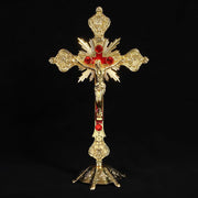 Vibrant religious cross ornament in gold with red accents, symbolizing faith and devotion.