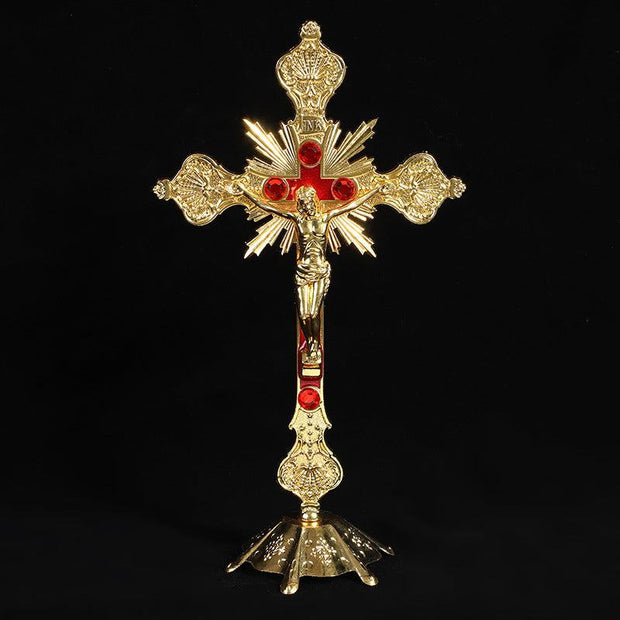 Vibrant religious cross ornament in gold with red accents, symbolizing faith and devotion.
