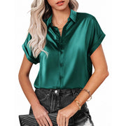 Elegant short sleeve blouse in green satin fabric paired with denim jeans.