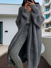 woman wearing gray long sleeve long knitted cardigan with jeans outdoors