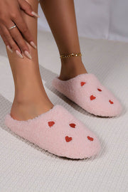Pink heart embroidered plush slippers with cushioned soles for comfort and warmth.