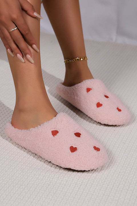 Pink heart embroidered plush slippers with cushioned soles for comfort and warmth.