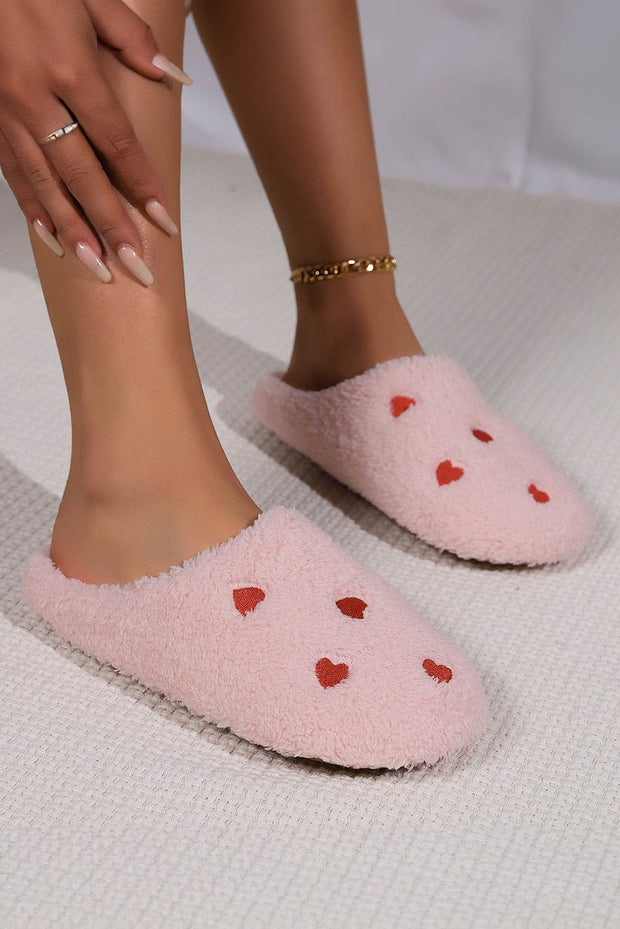 Pink heart embroidered plush slippers with cushioned soles for comfort and warmth.