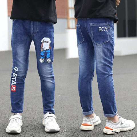 Boys denim jeans with stylish design, featuring cartoon patches and text details.
