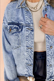 Dropped Shoulder Denim Jacket with relaxed fit and practical pockets, styled over beige top and dark pants.