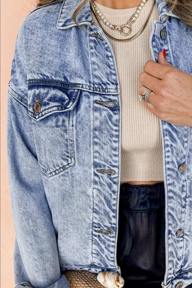 Dropped Shoulder Denim Jacket with relaxed fit and practical pockets, styled over beige top and dark pants.