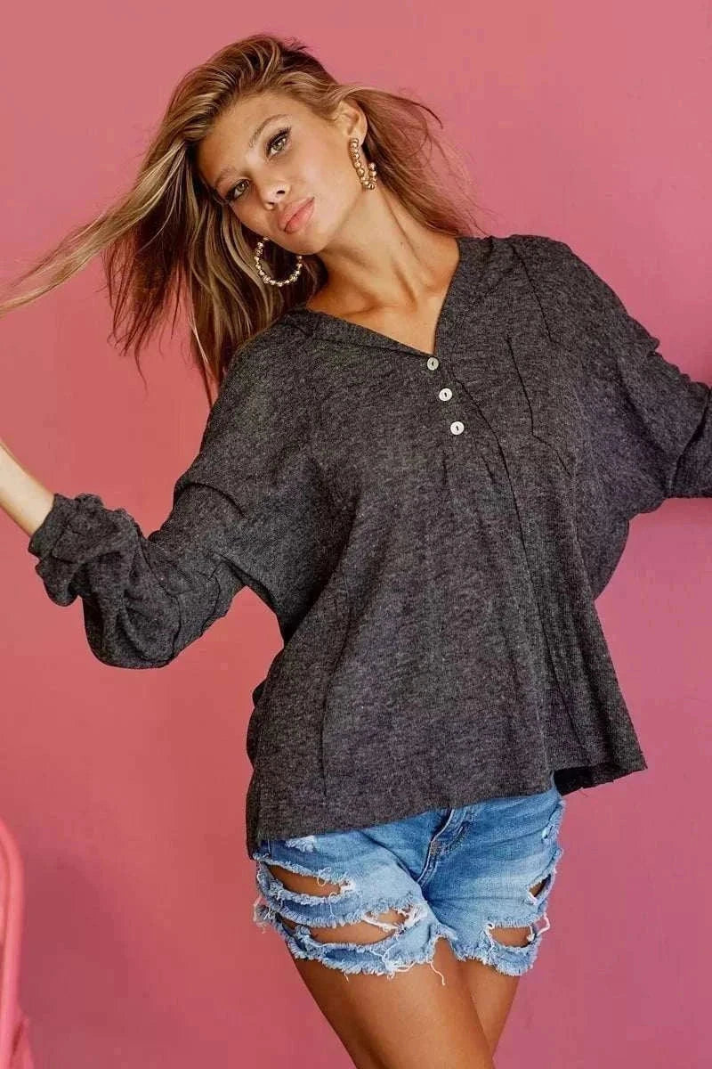 Woman wearing BiBi Textured Knit Hoodie from Hot Topic Goods in casual setting