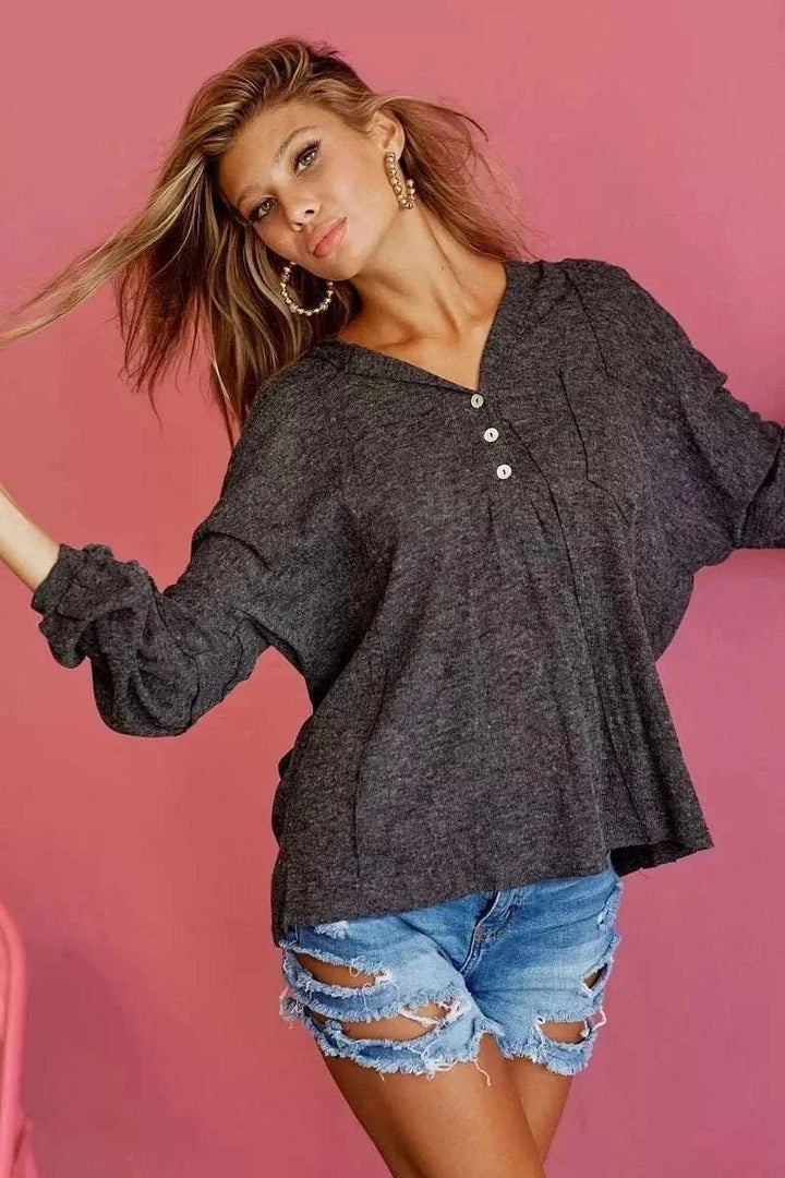 Woman wearing BiBi Textured Knit Hoodie from Hot Topic Goods in casual setting