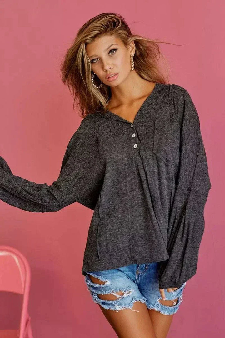 Woman wearing BiBi Textured Knit Hoodie from Hot Topic Goods in casual outdoor setting