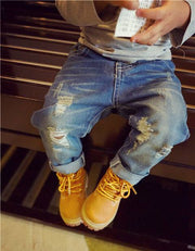 European style boys ripped jeans with trendy distressed details and cuffed hems.