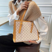 Large Capacity Handbag in a stylish design, carried by a woman sitting on a chair.