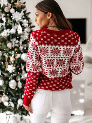 Woman wearing red and white long sleeve sweater with snowflake pattern standing near decorated Christmas tree
