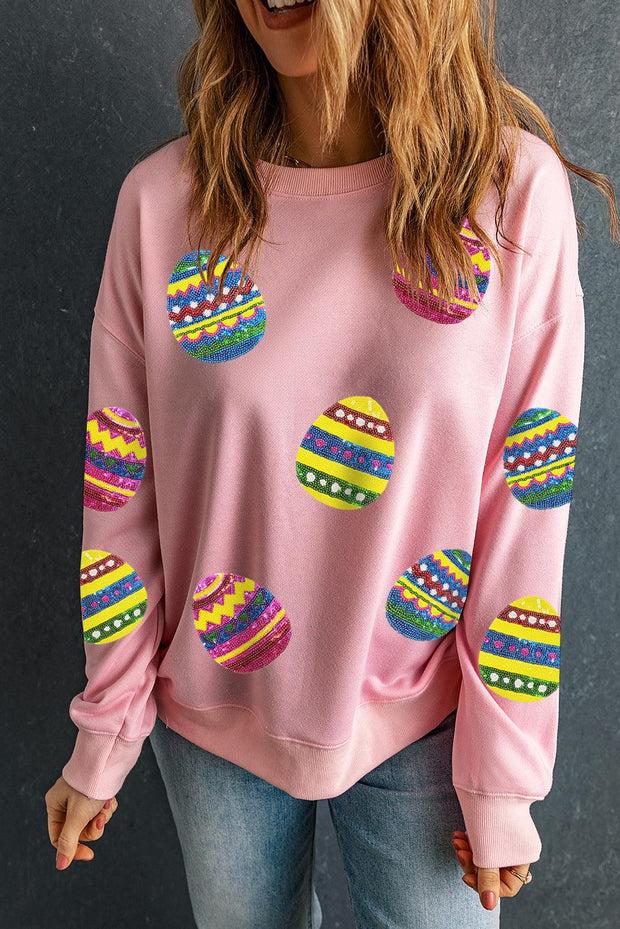 Pink crew neck sweatshirt with colorful Easter egg graphics, relaxed fit.