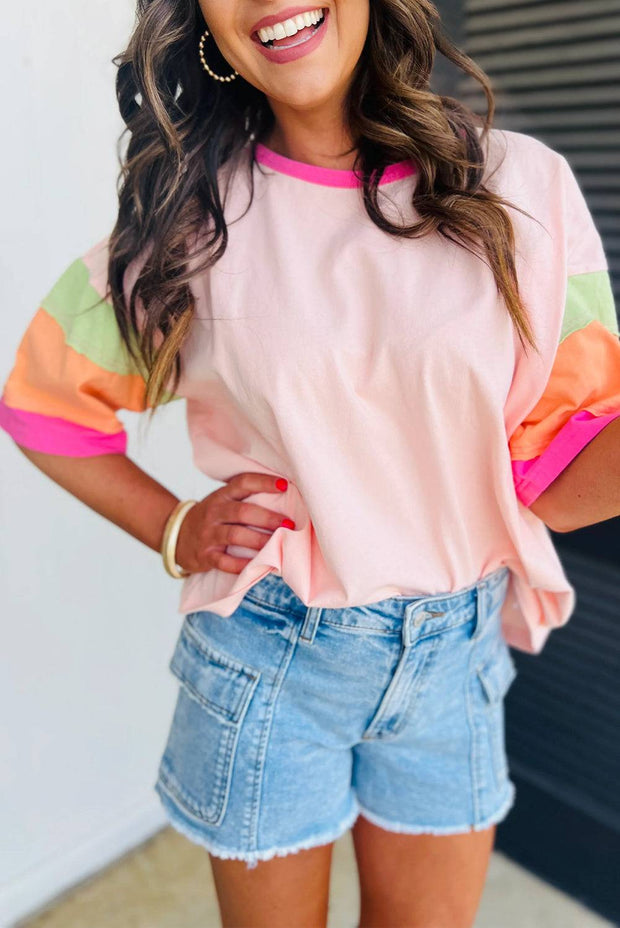 Green color block oversize top with round neckline and vibrant sleeves, paired with denim shorts.