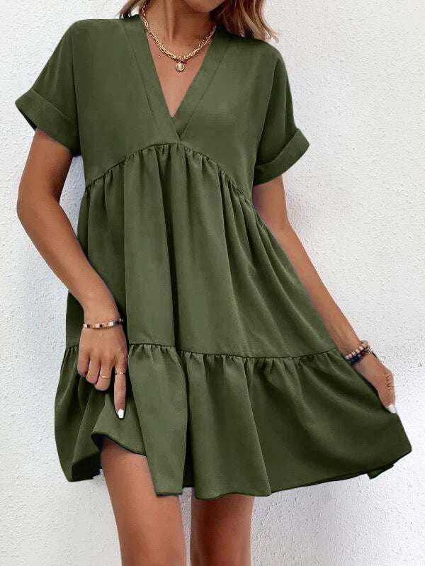 Short-sleeved V-neck dress in green with flowy skirt and elegant silhouette.