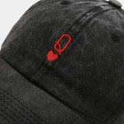 Vintage baseball cap with red heart and letter embroidery on black fabric.