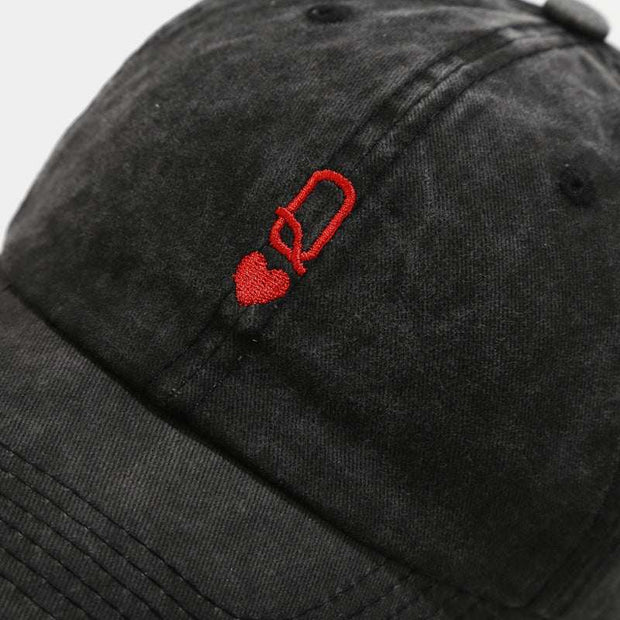 Vintage baseball cap with red heart and letter embroidery on black fabric.
