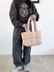 Large Capacity Hand Bag in beige held by person wearing casual attire.