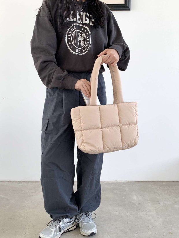 Large Capacity Hand Bag in beige held by person wearing casual attire.