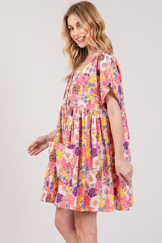 Floral babydoll dress with pockets and short sleeves on model.