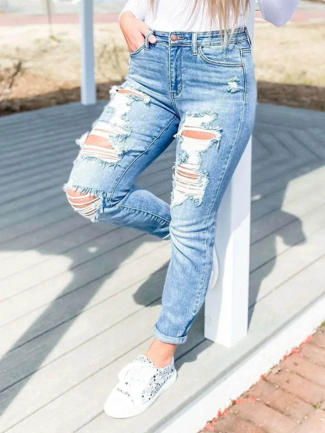 Women wearing distressed skinny denim jeans from Hot Topic Goods in a casual setting