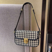 Houndstooth Baguette Bag with classic pattern on a chair.