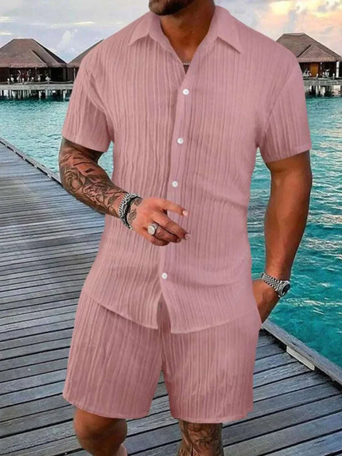 Plus Size Button Down Shorts Set in pink with short sleeves and button-up shirt, worn near a waterfront boardwalk.