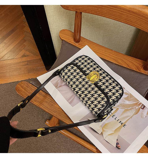 Houndstooth Baguette Bag with classic pattern on a wooden chair.