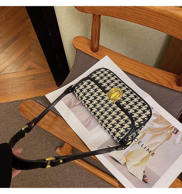 Houndstooth Baguette Bag with classic pattern on a wooden chair.