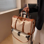Large Capacity Purse with leather accents on top of a suitcase.