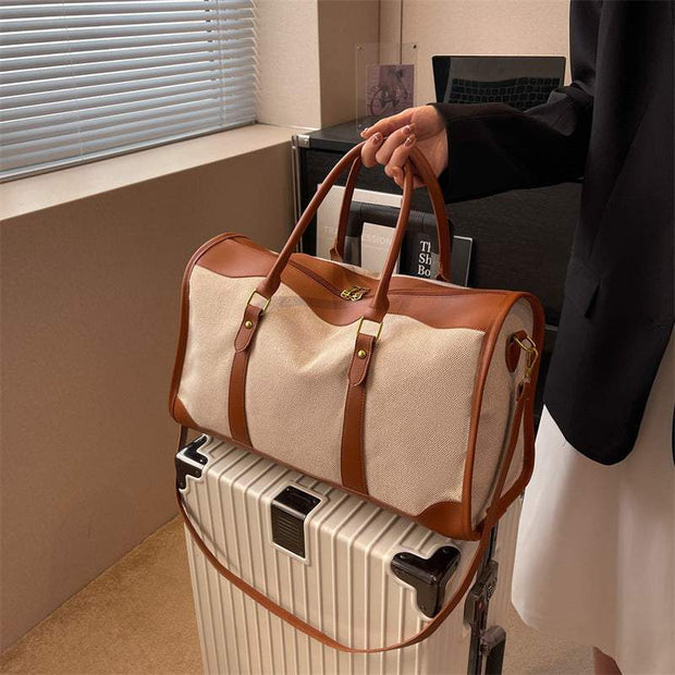 Large Capacity Purse with leather accents on top of a suitcase.