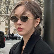 Contrast Womens Vintage Metal Oval Sunglasses worn by a person, featuring sleek oval frames with a stylish vintage design.