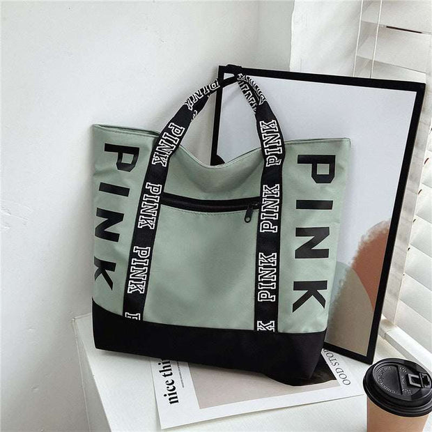 Large Capacity Handbag in green and black with "PINK" text design, featuring durable handles and front zipper pocket.
