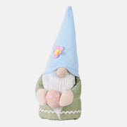 Easter Knitted Faceless Doll Hat with blue cone hat and green body, holding a pink egg, perfect for festive spring celebrations.