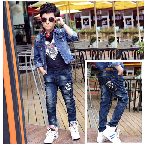 Boys wearing stylish denim jeans with patches, paired with a denim jacket and sneakers, outdoor setting.