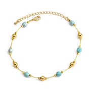Charm bracelet with gold beads and turquoise accents.