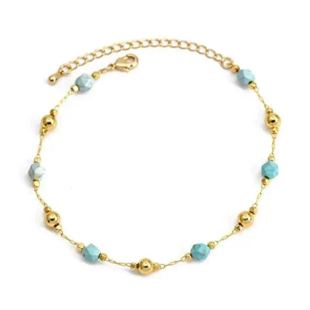 Charm bracelet with gold beads and turquoise accents.