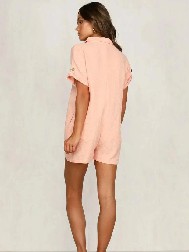 Woman wearing a pink button front short sleeve romper, showing back view and relaxed fit.