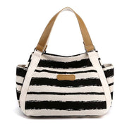 Stylish black and white striped one-shoulder tote with tan handles, perfect for daily use.