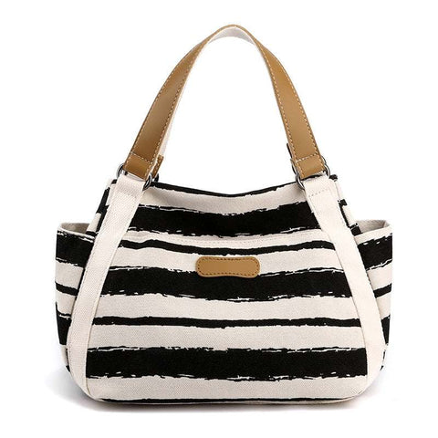 Stylish black and white striped one-shoulder tote with tan handles, perfect for daily use.