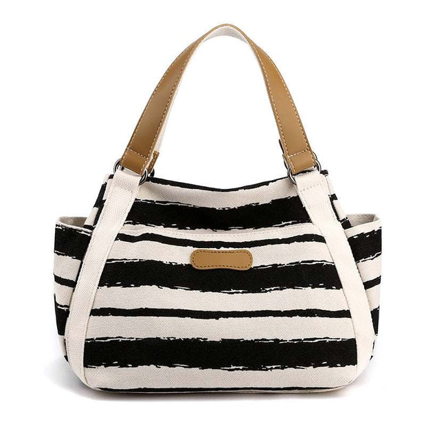 Stylish black and white striped one-shoulder tote with tan handles, perfect for daily use.