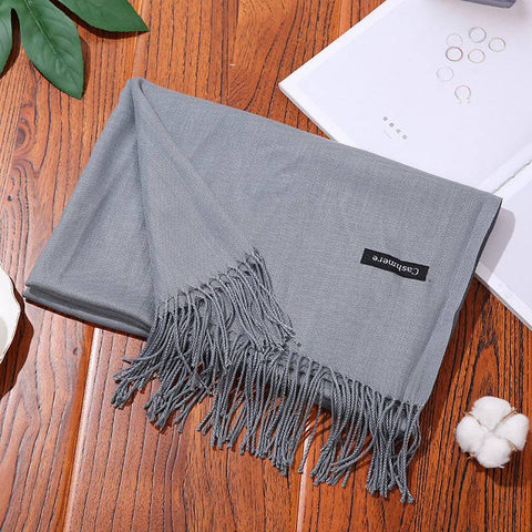 Designer Scarf Shawl with fringe on wooden table, showcasing stylish and versatile accessory.
