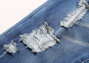 Close-up of European style boys ripped jeans showcasing distressed denim details.