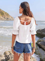 Ruffled square neck half sleeve blouse in white, worn by the ocean.