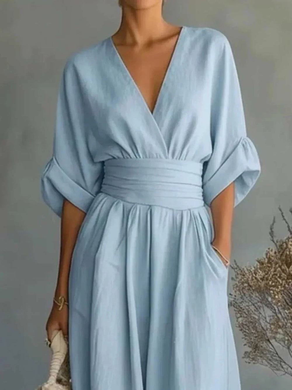 Woman wearing a full-size half sleeve wide leg jumpsuit with V-neckline and relaxed fit